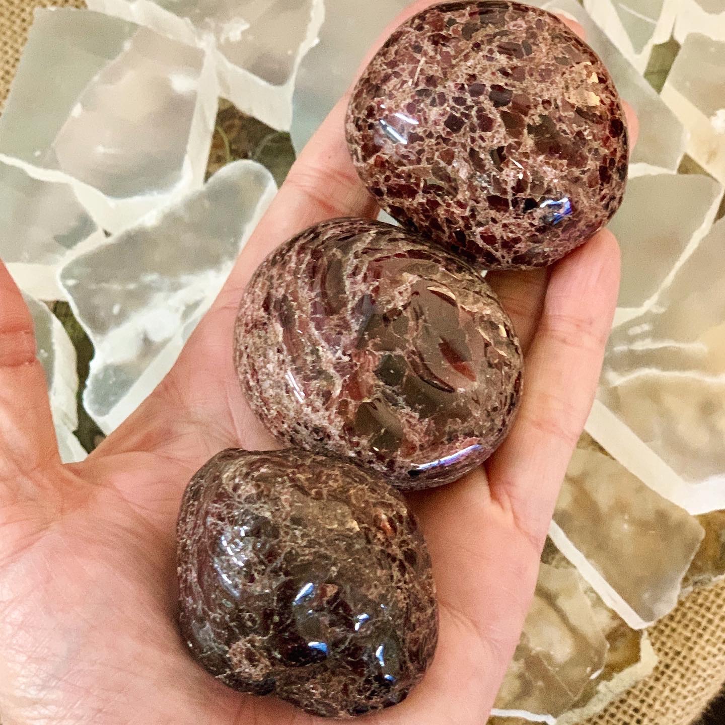 Three red Garnets the size of a palm lay in a hand.